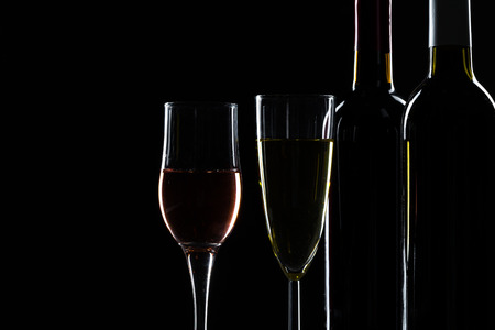elegant wine bottles and wine glass in a black backgroundの写真素材