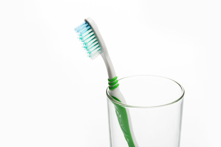 Set of colorful toothbrushes in glass on white background.の写真素材