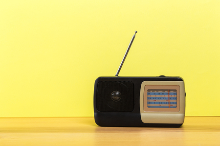 Vintage old radio on wooden table with color wall backgroundの写真素材
