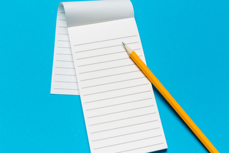 Blank paper notebook on blue background.Office desk table concept.の写真素材