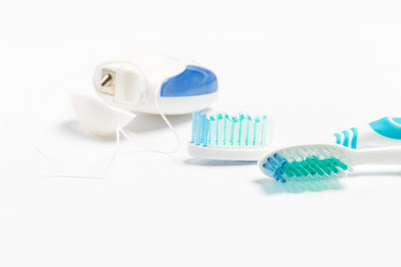 Dental floss and toothbrush on a white background.の写真素材