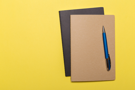 school notebook on a yellow background, notepad on a table.Top viewの写真素材