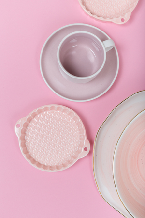 Empty plates and bowls on pink background. Top view with copy spaceの写真素材