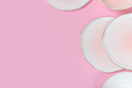 Empty plates and bowls on pink background. Top view with copy spaceの写真素材