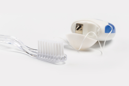 Dental floss and toothbrush on a white background.の写真素材