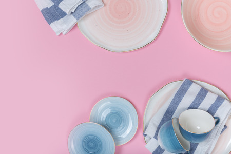 Empty plates and bowls on pink background. Top view with copy spaceの写真素材