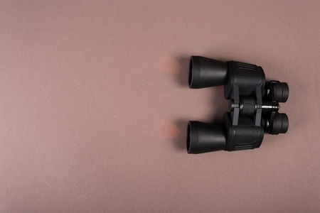 Black binoculars with orange lens on pastel backgroundの写真素材