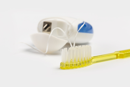 Dental floss and toothbrush on a white background.の写真素材