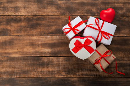 Gifts with red ribbon on the wooden table. Vintage gift box on wooden board with space for text.の写真素材