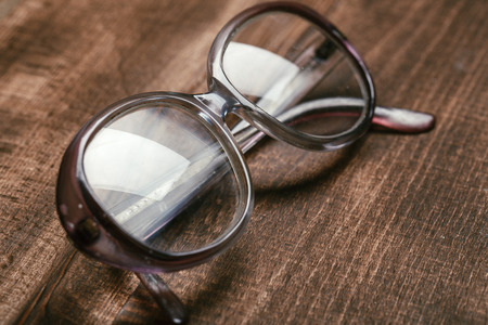 A pair of glasses on a wooden tableの写真素材