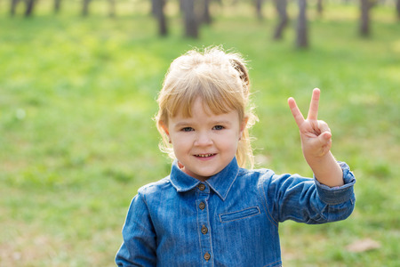 portrait of happy little girl with smile on face on sunny day in parkの写真素材