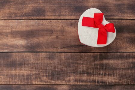 Gifts with red ribbon on the wooden table. Vintage gift box on wooden board with space for text.の写真素材