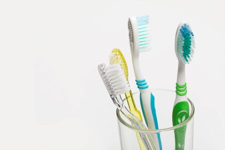 Set of colorful toothbrushes in glass on white background.の写真素材