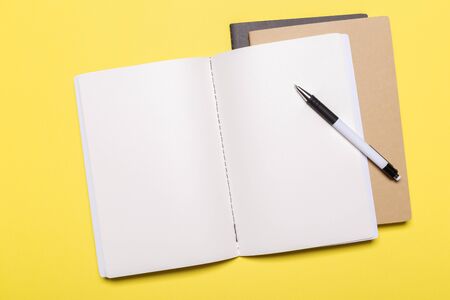school notebook on a yellow background, notepad on a table.Top viewの写真素材