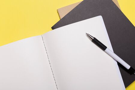 school notebook on a yellow background, notepad on a table.Top viewの写真素材