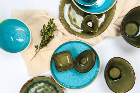 Simple rustic handmade blue crockery against white wooden wall: dish, stack of bowls.の写真素材