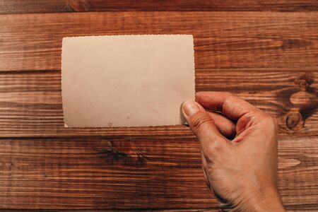 Stack old photos on table. Mock-up blank paper. Postcard rumpled and dirty vintage. Retro cardの写真素材