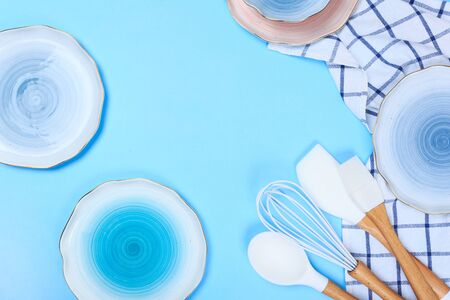 Varicolored ceramic plates and bowls on blue backgroundの写真素材