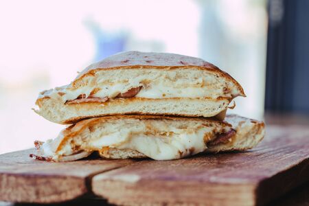 grilled sandwich with ham and cheese on wooden background. street foodの写真素材