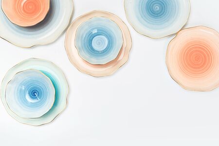 Varicolored ceramic plates and bowls on white backgroundの写真素材