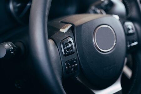 close up Modern black steering wheel with multifunction buttons Integrated stereo controls pushes...