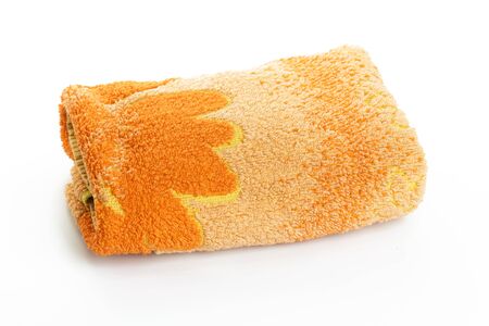orange neatly folded towel isolated on white backgroundの写真素材