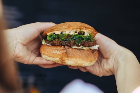 Close Up Of Woman Hands Holding Delicious Burgerの写真素材