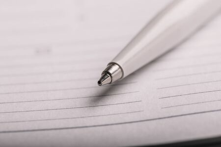 Opened notepad with automatic plastic ballpoint pen close up.の写真素材