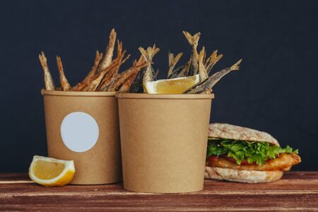 grilled sea fish with lemon wedges street food in box