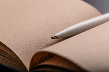 Opened notepad with automatic plastic ballpoint pen close up.