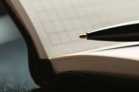 Opened notepad with automatic plastic ballpoint pen close up.の写真素材