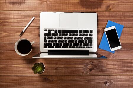 office stuff with notepad, laptop and coffee cup mouse notepad top view shot.の写真素材