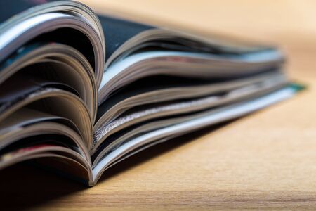 Colorful abstract background image of stacked magazines on wooden tableの写真素材