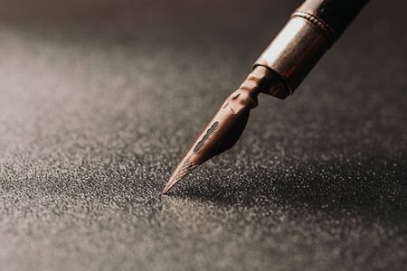 Old fountain pen on a black textured backgroundの写真素材