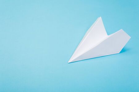 Flat lay of white paper plane and blank paper on pastel blue color background.の写真素材