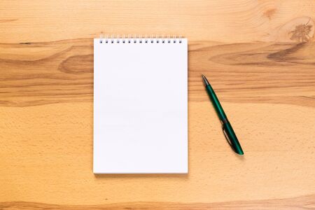 school notepad and pen on the wooden desk. spiral notepad
