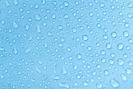 Rain droplets on blue glass background, Water drops on blue glass.の写真素材