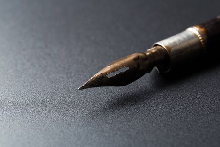 Old fountain pen on a black textured backgroundの写真素材
