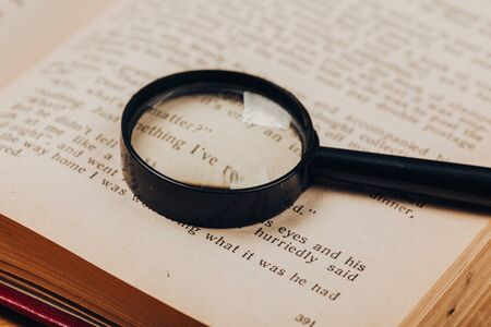 Small magnifying glass on paper with text. search, analysis, studyの写真素材