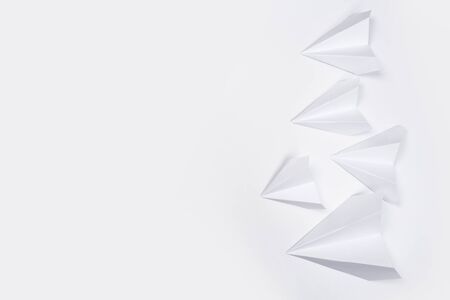 white paper airplane on a white paper backgroundの写真素材