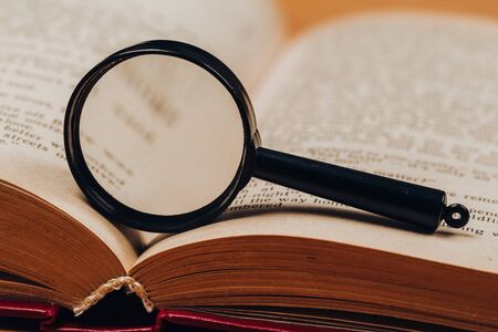 Small magnifying glass on paper with text. search, analysis, studyの写真素材