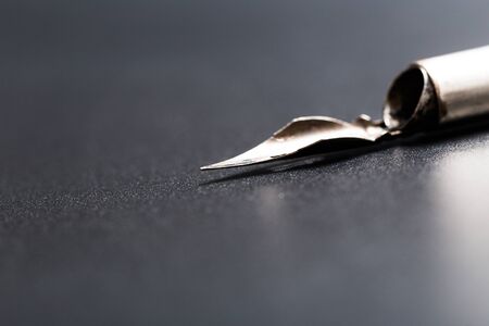 Old fountain pen on a black textured backgroundの写真素材