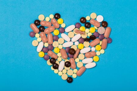 Assorted pharmaceutical medicine pills, tablets and capsules for the treatment of heart disease. Heart shape of pills. Copy space for textの写真素材
