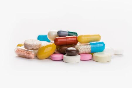 Assorted pharmaceutical medicine pills, tablets and capsules over white background
