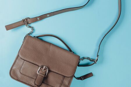 Fashion concept : Flat lay of brown leather woman bag open out with cosmetics, accessories and smartphone on pink backgroundの写真素材