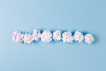 Crumpled paper balls, waste and recycling concept on blue backgroundの写真素材