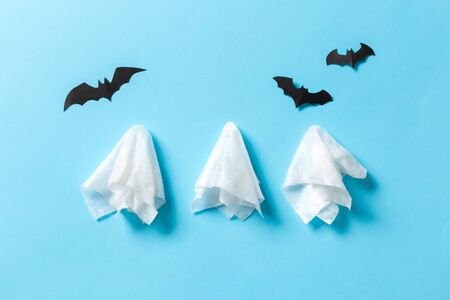 White ghost sheet costume against pastel blue background. Minimal Halloween scary concept.の写真素材