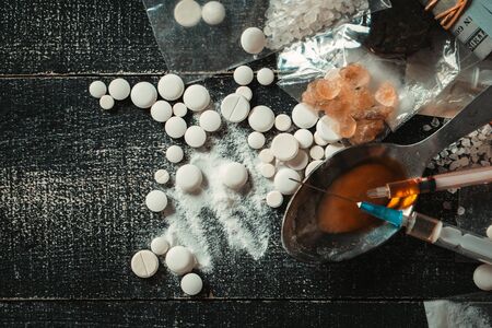 Hard drugs on dark table. Drug syringe and cooked heroinの写真素材