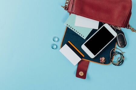 Fashion concept : Flat lay of brown leather woman bag open out with cosmetics, accessories and...