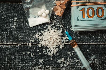 Hard drugs on dark table. Drug syringe and cooked heroin